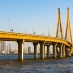 Stunning view of Bandra-Worli Sea Link with Mumbai skyline at sunset, reflecting on the Arabian Sea.