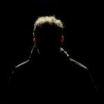 Silhouette of a man isolated in darkness, creating a mysterious ambiance.
